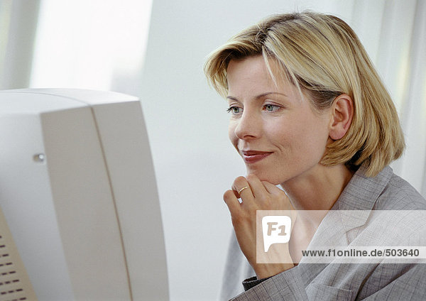 Geschäftsfrau am Computerbildschirm  lächelnd