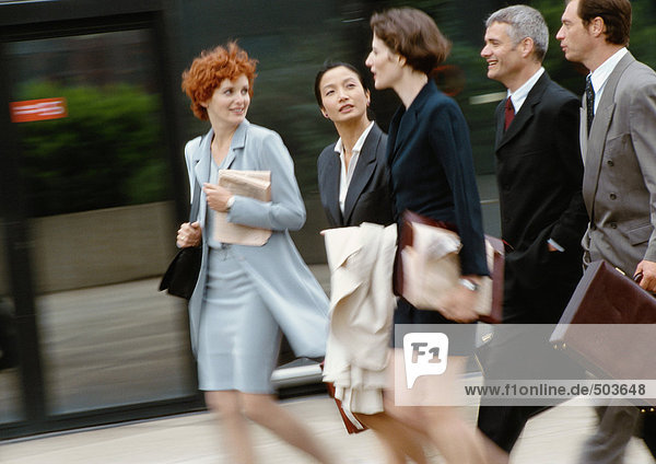 Group of business people walking side by side  blurred