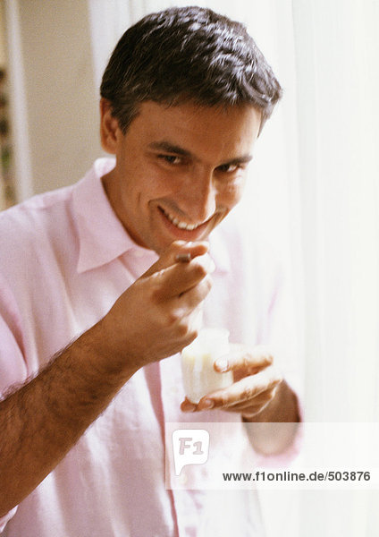 Mann isst Joghurt  Porträt  unscharf
