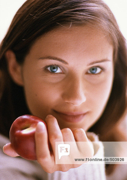 Frauenkopf  Hand hält roten Apfel  Nahaufnahme