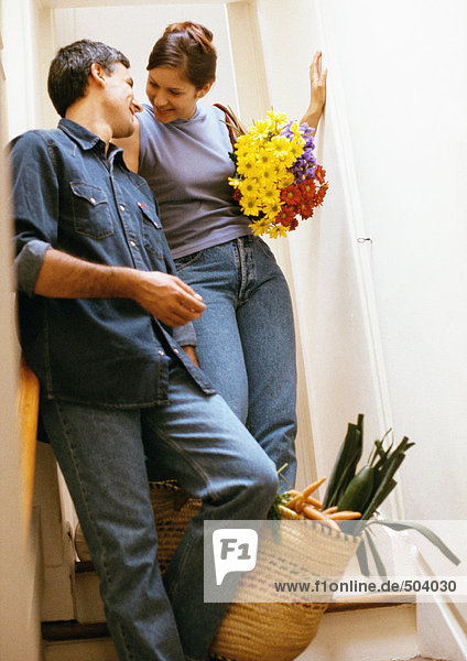 Paar an die Wand gelehnt  Frau mit Blumenstrauß