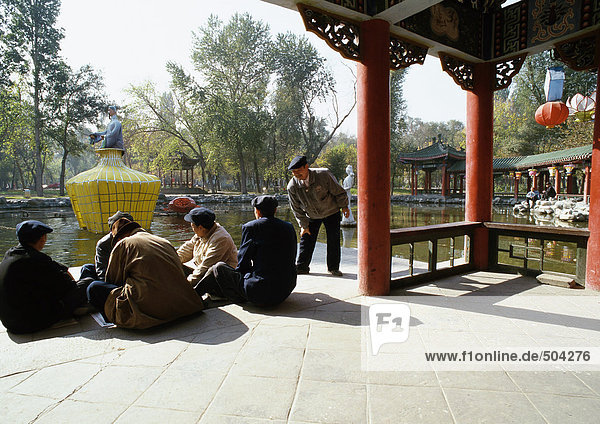 China  Provinz Xinjiang  Urumqi  Männergruppe auf Pagodenboden  Park im Hintergrund