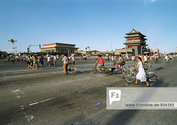 China  Peking  Tiananmen-Platz  Menschen  die mit dem Fahrrad auf der Straße gehen und fahren.