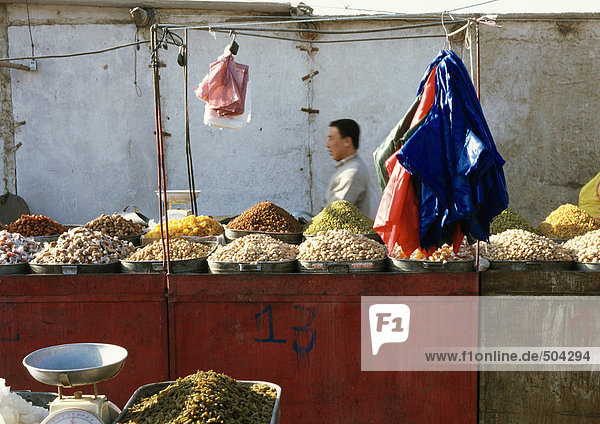 China  Xinjiang  Turpan  Mann hinter Stall im Freiluftmarkt