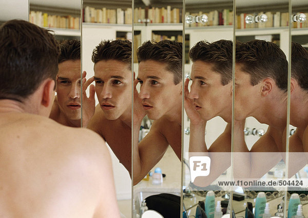 Mann berührt Augenbraue  Fokus auf Mehrfachreflexionen in Spiegeln