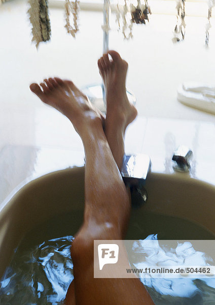 Aus der Badewanne ragende Beine