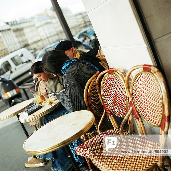 Teenager sitzen auf der Caféterrasse