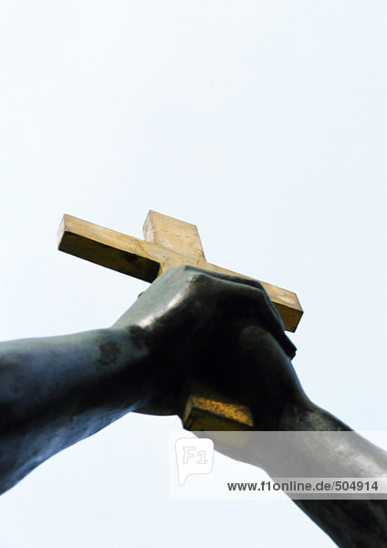 Statue  hands holding crucifix  low angle view