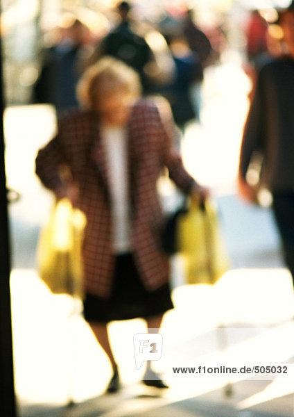Woman carrying bags in street  blurred
