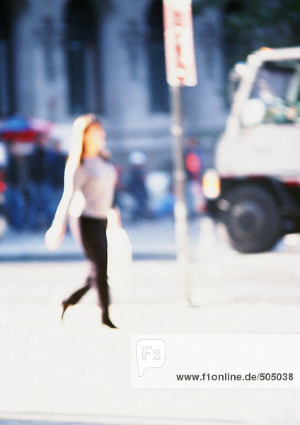 Woman holding bag  walking in street  blurred