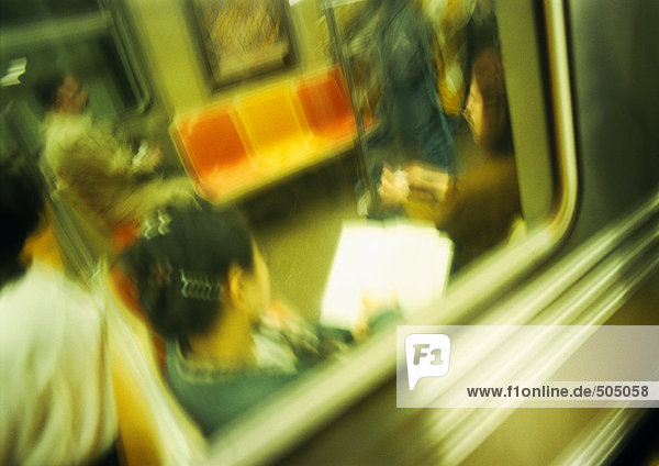 People in subway  viewed from outside  blurred