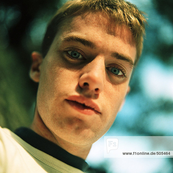 Young man outside  looking at camera  close up  portrait  low angle view