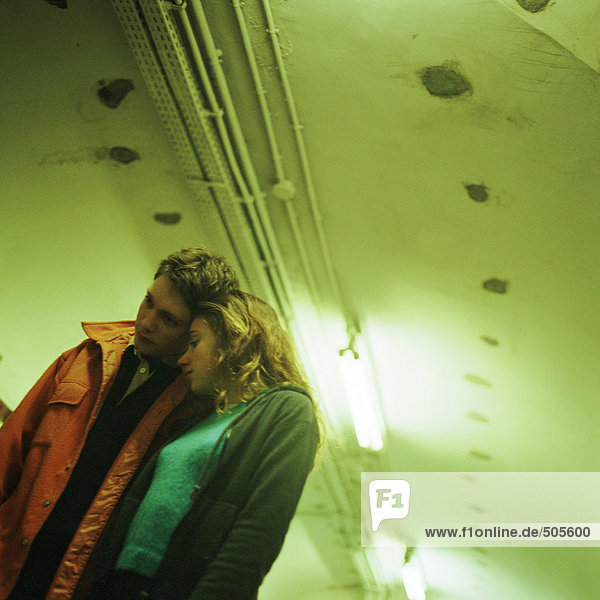 Junge Menschen  die sich im U-Bahn-Korridor aneinander lehnen