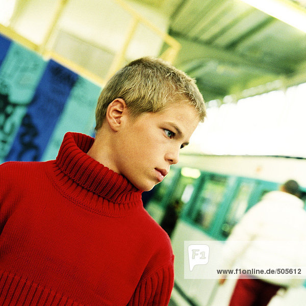 Teenager Junge stehend  Kopf und Schultern  mit U-Bahn im Hintergrund