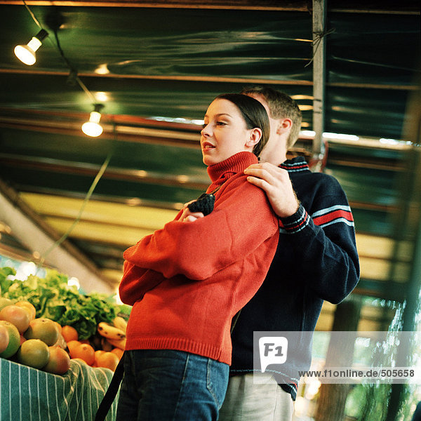 Young couple next to produce at market  low angle view