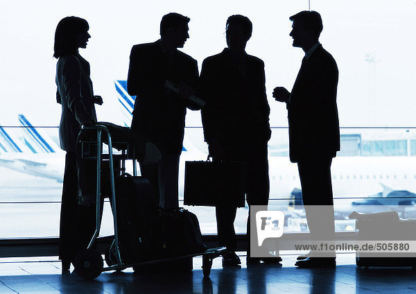 Group of business people standing inside airport  silhouette.