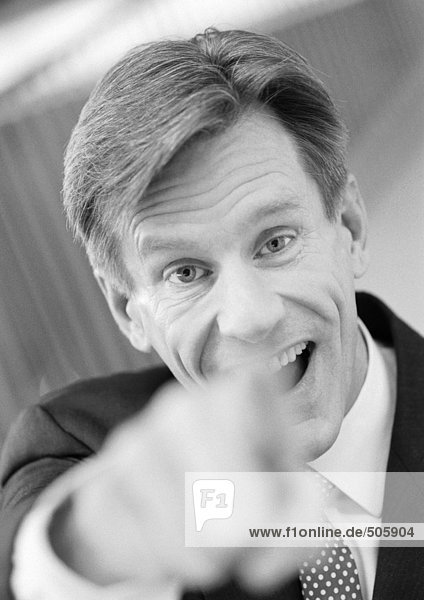 Geschäftsmann zeigt auf die Kamera  Hand im Vordergrund verschwommen  schwarz-weiß  Nahaufnahme  Porträt.