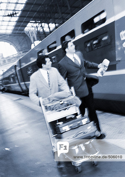 Geschäftsleute  die auf dem Bahnsteig neben dem Zug laufen  s/w.