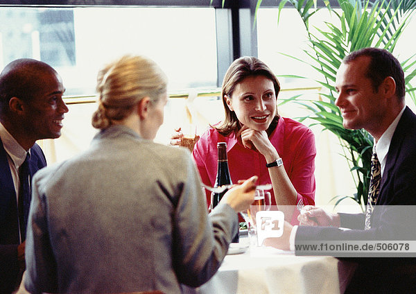 Gruppe von Geschäftsleuten  die am Tisch sitzen  essen  schließen.