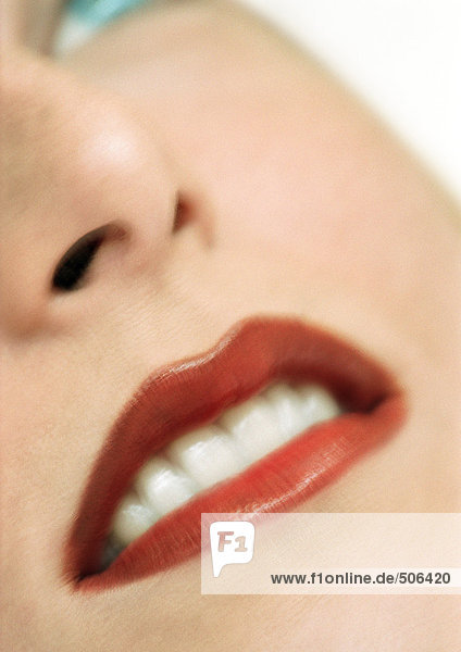 Frau mit rotem Lippenstift  Nahaufnahme  Teilansicht des Gesichtes  unscharf  Mund