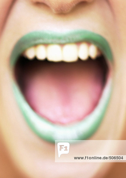 Close up of woman's mouth open and smiling with green lipstick  blurred mouth