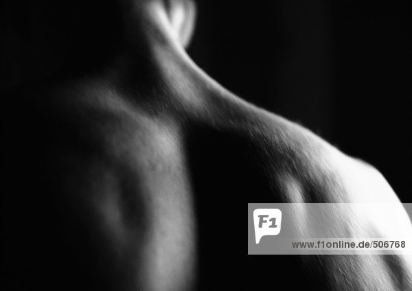 Man's bare upper back  blurred  close-up  black and white.