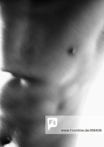 Man's bare chest and abdomen  blurred  close-up  black and white.