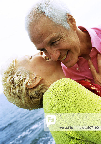 Mature couple embracing  laughing  close-up