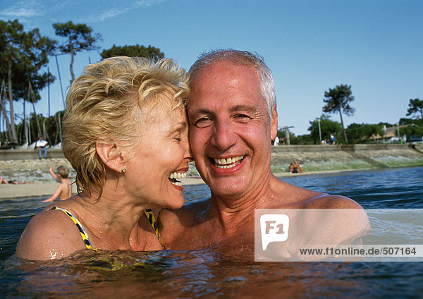 Mature couple standing in water at the beach  close-up