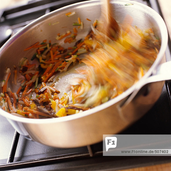 Close-up of food being stirred in pan on stove