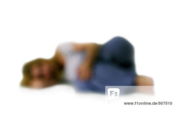 Silhouette der Frau seitlich auf dem Boden eingerollt  auf weißem Grund  defokussiert