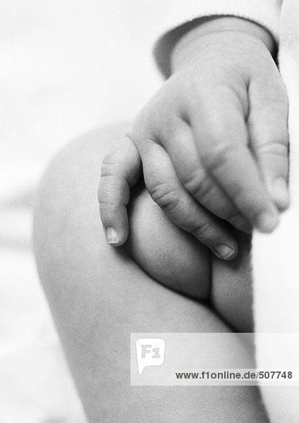 Baby's hand on leg  close-up
