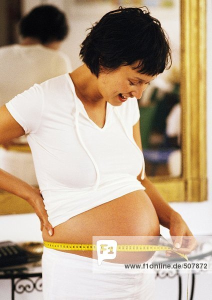 Pregnant woman measuring her stomach