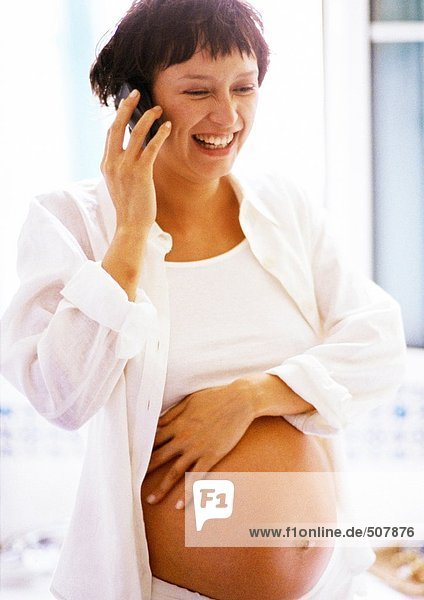 Schwangere Frau mit Handy,  lächelnd
