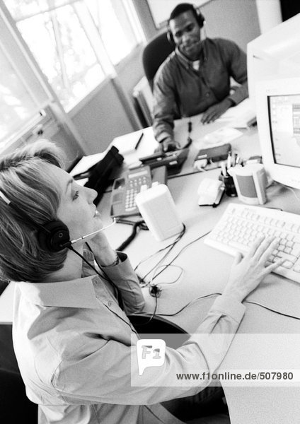Businesswoman and colleague wearing headsets  B&W