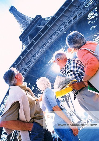 Frankreich  Paris  reife Touristen mit Blick auf den Eiffelturm  Blick von unten