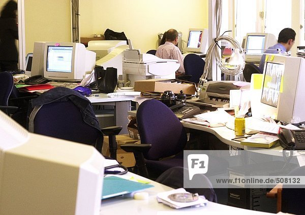Schreibtische und Computer im Büro  Mitarbeiter im Hintergrund