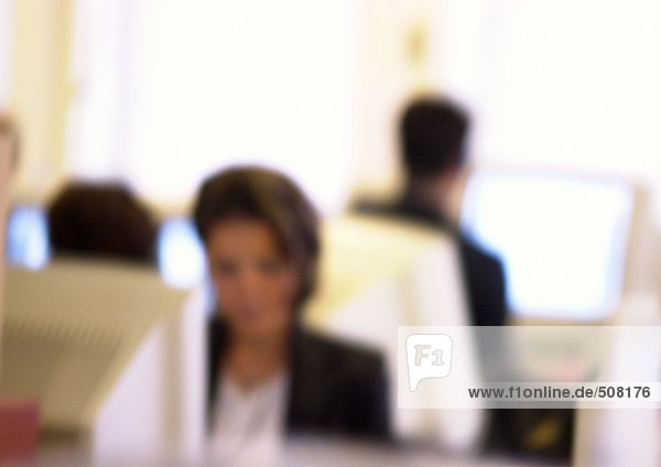 People working at computers in office  blurred