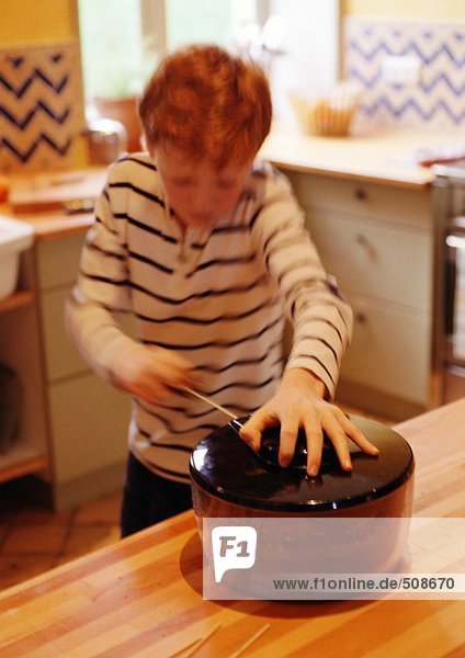 Kind mit Salatschleuder in der Küche  verschwommene Bewegung