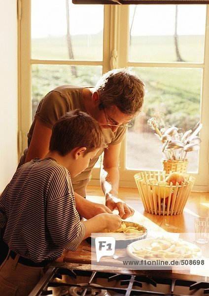 Mann und Kind machen Apfelkuchen