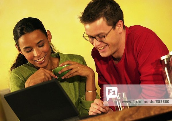 Mann und Frau mit Laptop-Computer  lächelnd