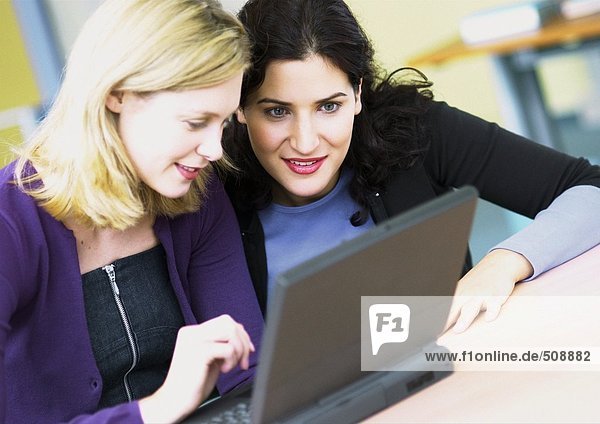Two women using laptop computer
