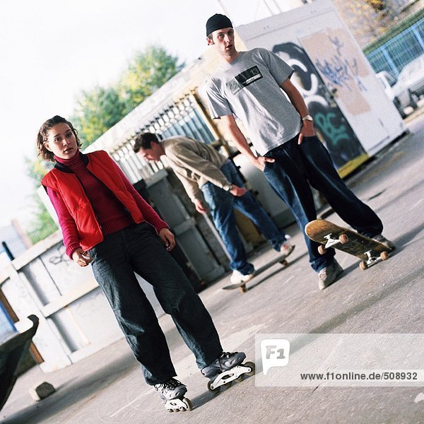 Jugendliche mit Inlineskates und Skateboards