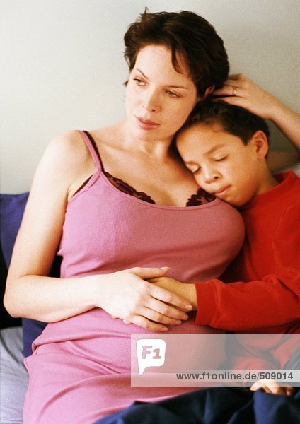 Schwangere Frau sitzend mit Kind