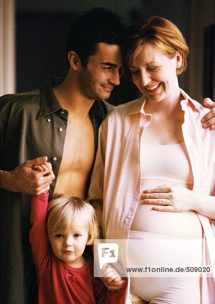 Schwangere Frau und Mann stehend mit Kind  lächelnd  Portrait