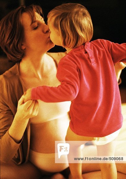 Schwangere Frau küssendes Kind