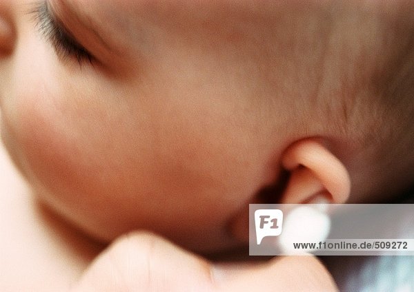 Baby mit Ohrenreinigung mit Wattestäbchen,  Nahaufnahme