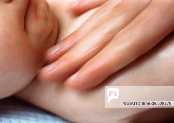 Erwachsene Finger auf der Brust des Babys  Nahaufnahme