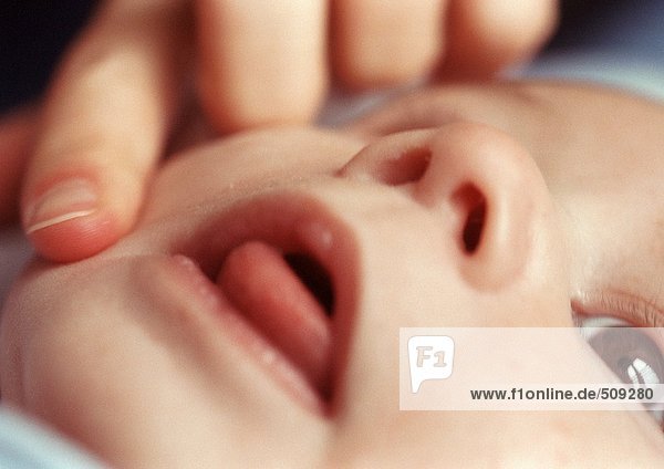 Erwachsener berührt das Gesicht des Babys  Nahaufnahme