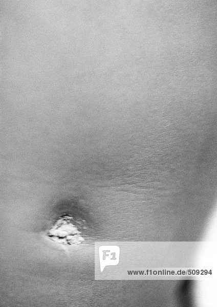 Baby's belly with baby powder in naval  close-up  b&w